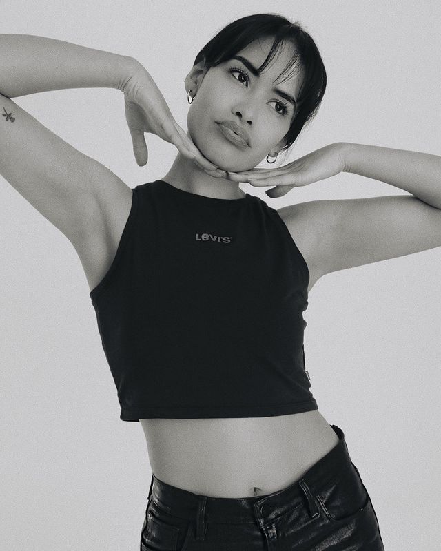 Sulem Calderon posing in a black top and jeans.